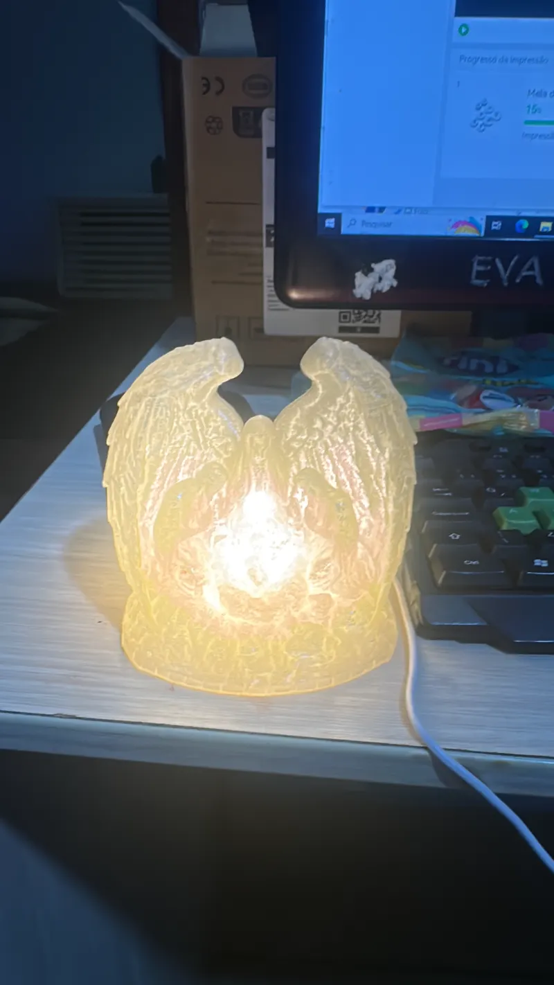 Luminária impressa em 3D acesa ao lado do computador acompanhando a impressão