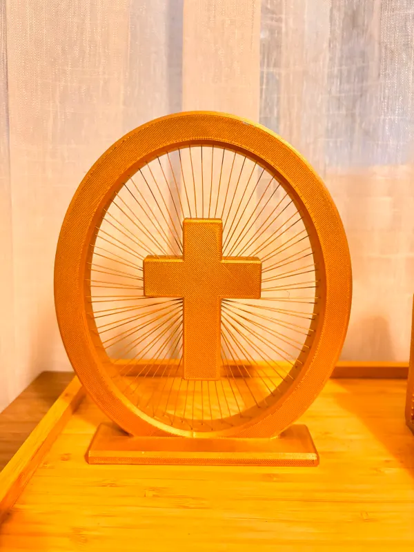 Cruz com resplendor de raios impressa em 3D em dourado